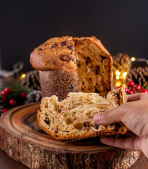 Woman taking slice of delicious Panettone cake closeup