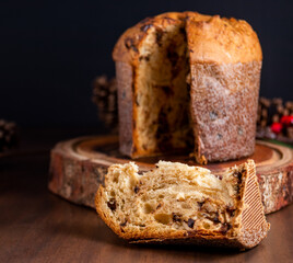 Slice of delicious Panettone with chocolate for Christmas. On wooden table