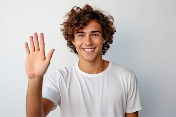 A young man in a stylish t-shirt confidently gives a high-five, radiating happiness.