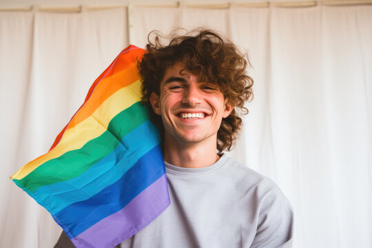 Confident LGBTQ+ rights advocate holds rainbow flag, a symbol of diversity and freedom.