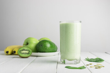 Green detox smoothie, blended vegetarian drink in a glass from spinach, apple, banana, kiwi,...