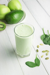 Green detox smoothie, blended vegetarian drink in a glass from spinach, apple, kiwi, avocado and...