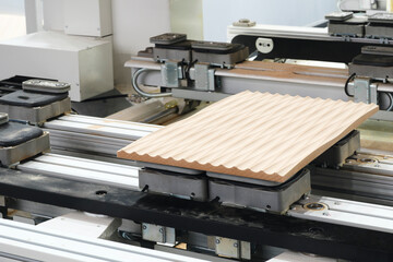 Wood boards on a woodworking machine in a modern furniture factory, woodworking industrial concept background
