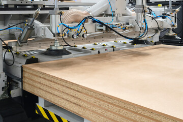 Wood boards on a woodworking machine in a modern furniture factory, woodworking industrial concept...