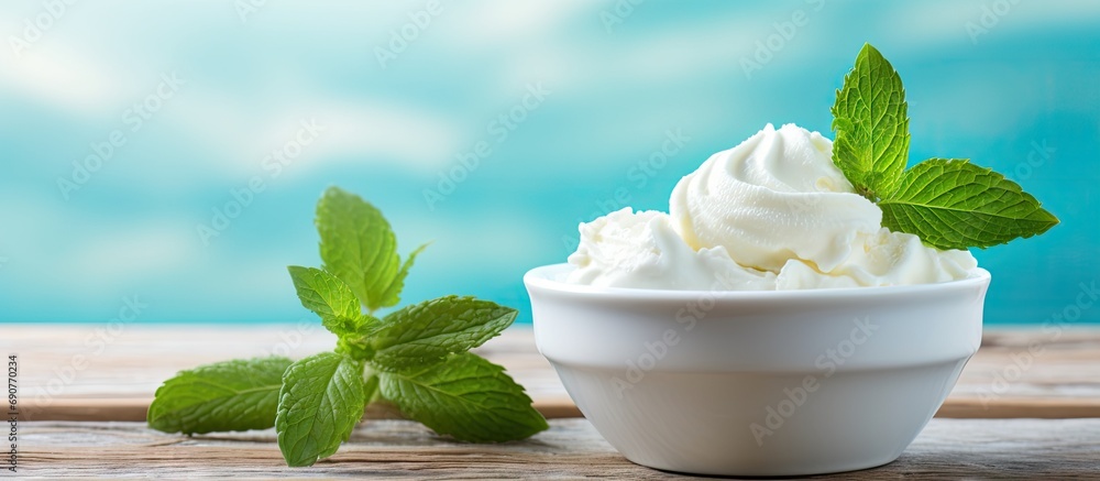 Aufkleber vanilla ice cream balls with mint leaves in a turquoise bowl on a turquoise wooden table. copyspace 