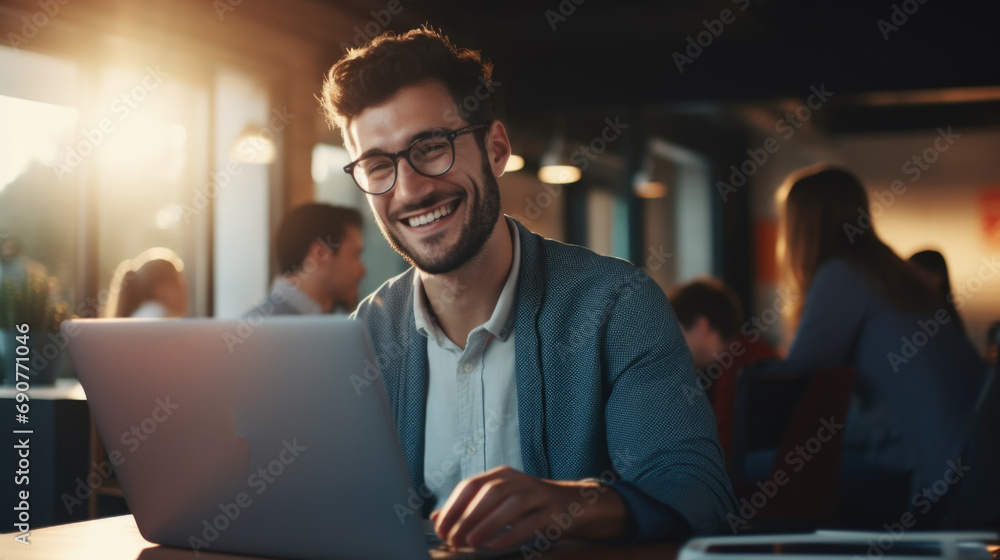 Poster A man sitting at a table using a laptop computer. Suitable for technology-related projects