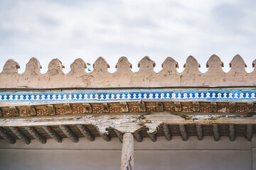A column carved from wood holds the roof vaults of a building in Khiva in Khorezm, wood texture,...