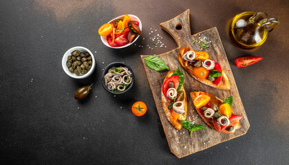Fototapeta na wymiar Toast tapas with anchovies, tomato on bread. Traditional italian appetizer or snack, antipasto