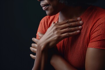 A woman standing with her hands placed on her chest in a calm and serene manner. This image can be used to portray emotions such as gratitude, surprise, or admiration.