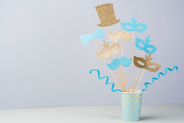 Purim celebration concept. Masks, bow, hat, mustached on a stick with the Jewish flag. Festive...