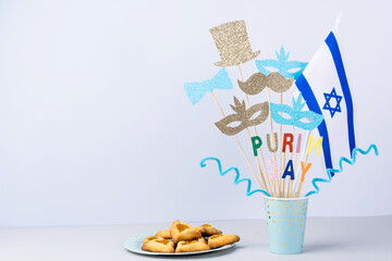 Paper prop masks on a stick, bow, hat, mustached with colored letters Purim Day on a gray...