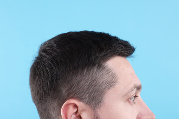 Obraz premium Man with healthy hair on light blue background, closeup