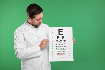 Fototapeta na wymiar Ophthalmologist with vision test chart on green background