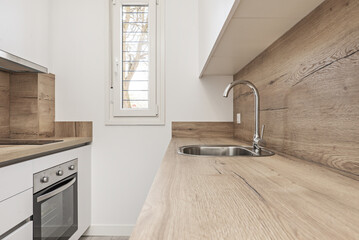 stainless steel sink on a wooden countertop and faucet of the same material in a loft-style...