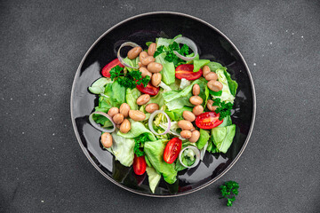 white bean salad green lettuce, tomato, onion, salad dressing ready to eat healthy eating cooking appetizer meal food snack on the table copy space food background rustic top view keto or paleo diet