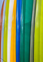 Vertical closeup of a rack of colorful surfboards for sale in a surf shop