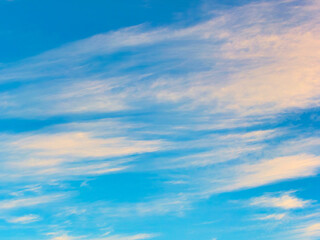 High Cirrus clouds tinged with warm light on a December morning sunrise.