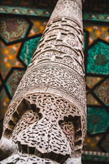 Fototapeta na wymiar Wood texture of a column on an ancient building in the ancient city of Khiva in Khorezm, wood carving in macro