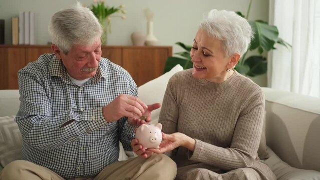 Saving money investment for future. Senior adult mature couple holding piggy bank putting money coin. Old man woman counting saving money planning retirement budget. Saving investment banking concept
