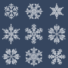 A set of stylish white quilling snowflakes on a dark blue background. Paper openwork weaving technique. Elements of quilling. New Year's symbols in the pattern.