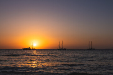 Three Sailboats at Sunset.