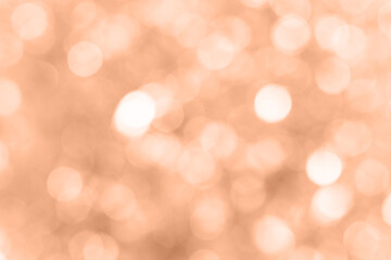 Blurred background with holiday lights. Showcasing the color of 2024 peach