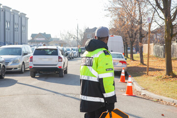 Security guard conducting access control, traffic control, and parking enforcement duties around a...