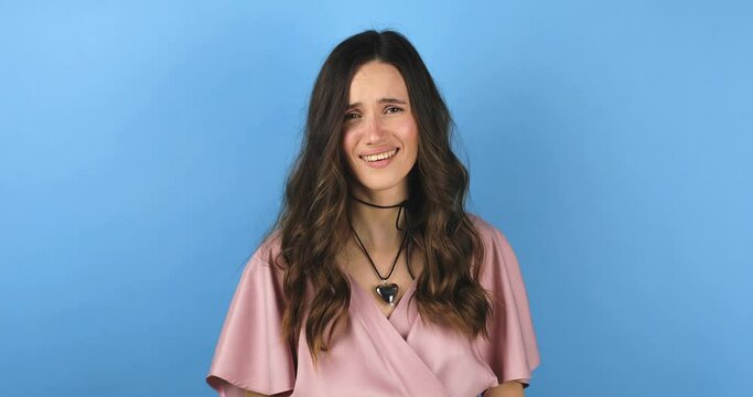 Fake, crying woman face in studio with hands gesture for sad, bullying or gesture on blue background. Tears, face and female joke, cry and sign on mockup with unhappy boo emoji or fist of loser.