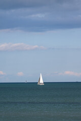 Weißes Seegelboot vor Horizont