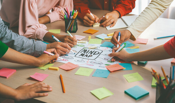 Creative business team brainstorming about marketing strategy and business plan by using mind mapping. Startup team work together to write down on paper. Focus on hand. Closeup. Variegated. - Powered by Adobe