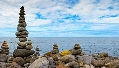 high stack of pebbles on the beach and sea background