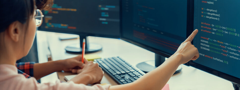 Female programer taking a note while young skilled web developer present program while computer displayed program code at modern office company. Java script, web design concept. Burgeoning.