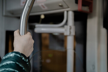 Woman holding hand rail in a bus