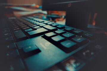 A close-up photo of a computer keyboard on a desk - obrazy, fototapety, plakaty