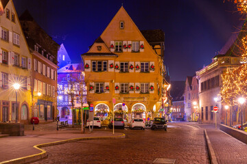 Fototapeta na wymiar Decorated and illuminated half-timbered house in Old Town at Christmas night, Colmar, Alsace, France