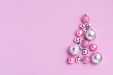 Christmas composition of Christmas tree made of pink ball decoration on pink background. New Year sale card, copy space