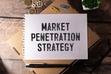 On the table is a notebook, a pen and a business card with the inscription - MARKET PENETRATION