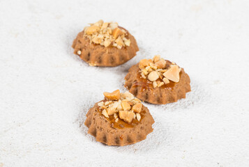 Mini cookies with caramel and peanuts. White background