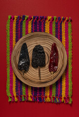Dried Chilis on wood dish Red background Pasilla and Guajillo mexican spice