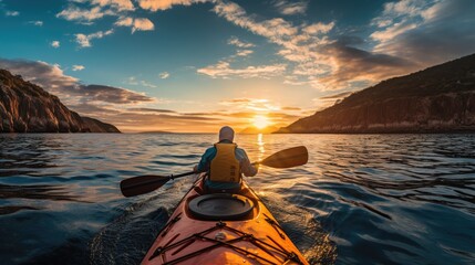 man in kayak rowing with paddle at sea during sunset - obrazy, fototapety, plakaty