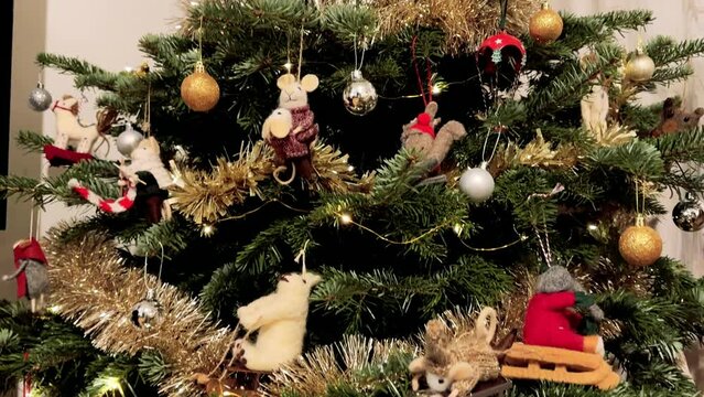 Sapin de No&euml;l d&eacute;cor&eacute;, en int&eacute;rieur, en appartement, avec des guirlandes argent&eacute;es, dor&eacute;es, et des guirlandes lumineuses, des p&egrave;res No&euml;l, des souris en peluche
