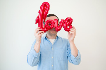 Valentines day concept. Portraint of happy man looking thriugh balloon