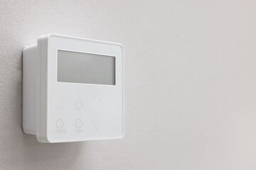 One thermostat on white wall, space for text. Smart home system