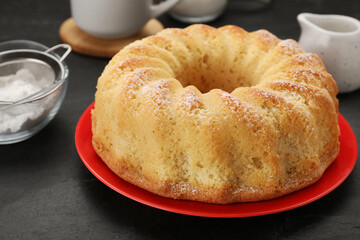 Delicious freshly baked sponge cake on black table, closeup