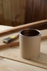 Can with wood stain on wooden surface