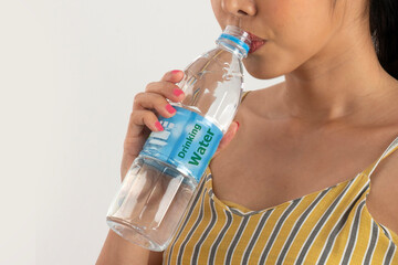 Woman drinks water from PET bottle.