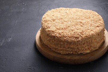 Delicious Napoleon cake on black table, closeup. Space for text