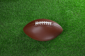 Leather American football ball on green grass