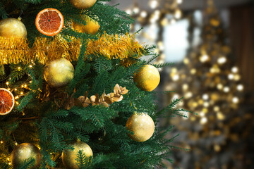 Obraz na płótnie Canvas Christmas tree decorated with golden festive balls against blurred background, bokeh effect. Space for text