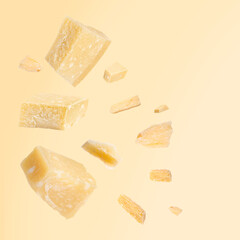 Tasty parmesan cheese in air on beige background
